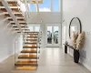 Foyer with a towering ceiling, light tile patterned flooring, french doors, and plenty of natural light