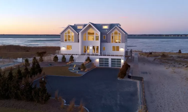 View of front of house with a garage and a water view