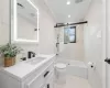 Full bathroom with toilet, enclosed tub / shower combo, vanity, ornamental molding, and tile walls