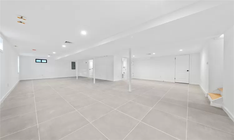 Basement with light tile patterned flooring