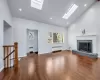 Open layout Living Room area anchored by wood-burning fireplace with new hardwood flooring