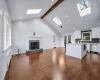 Living Room with wood-burning fireplace with a vaulted ceiling, 4 skylights and new hardwood flooring