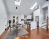 Dining space with vaulted ceiling, dark hardwood / wood-style flooring, and radiator heating unit