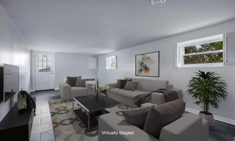 Living room with plenty of natural light, radiator heating unit, and tile patterned flooring