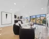 Living room with floor to ceiling windows, vaulted ceiling, and light parquet floors