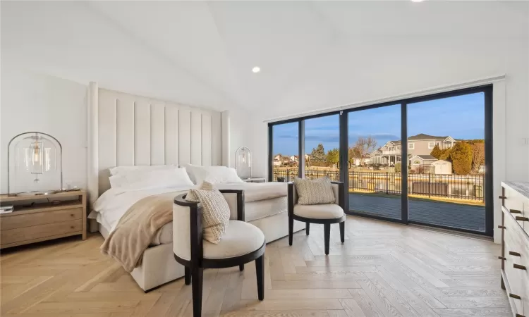 Bedroom featuring high vaulted ceiling, light parquet flooring, and access to outside