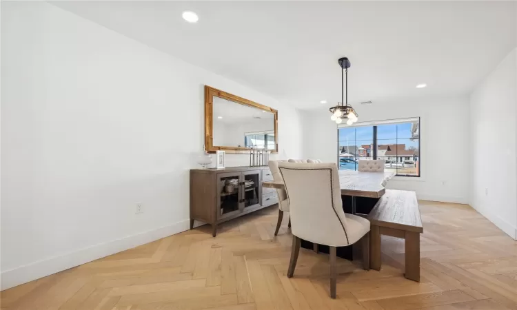 Dining space with an inviting chandelier and light parquet floors