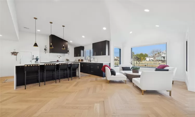 Living room featuring high vaulted ceiling and light parquet floors