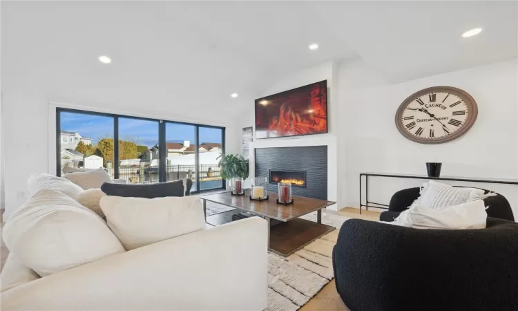 Living room with vaulted ceiling and light hardwood / wood-style flooring