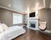 Bedroom featuring dark wood-type flooring, a tiled fireplace, and ornamental molding