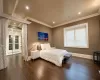 Bedroom featuring dark hardwood / wood-style flooring, ornamental molding, and access to exterior