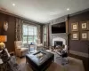 Living room featuring wood-type flooring, a fireplace, and crown molding