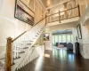 Stairs with a high ceiling, decorative columns, ornamental molding, and wood-type flooring