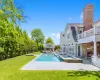 View of swimming pool featuring an in ground hot tub, a yard, an outdoor structure, and a patio area