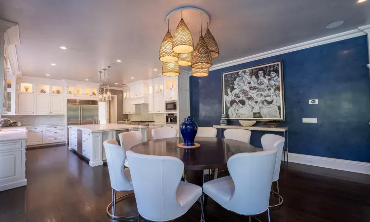 Dining room featuring sink, ornamental molding, and dark hardwood / wood-style floors