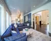 Living room featuring decorative columns, crown molding, and hardwood / wood-style flooring