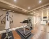 Exercise room featuring ornamental molding, a fireplace, and hardwood / wood-style flooring