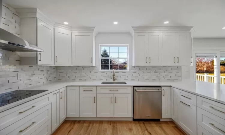 Kitchen with white cabinets, dishwasher, tasteful backsplash, and sink