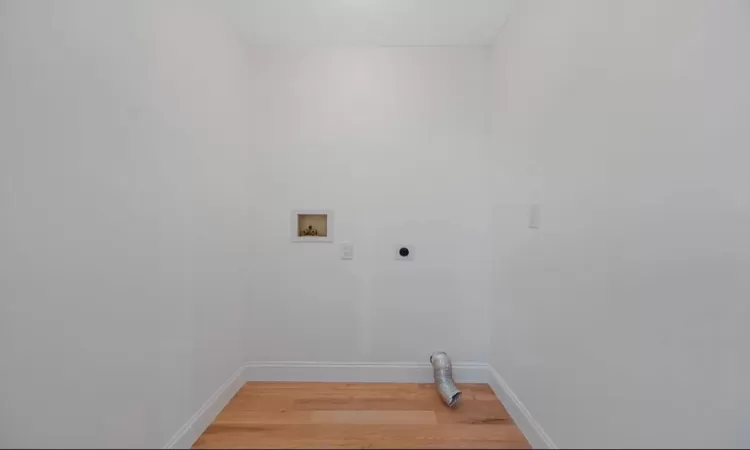 Clothes washing area with washer hookup, light hardwood / wood-style flooring, and hookup for an electric dryer