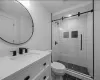 Bathroom featuring toilet, tile patterned flooring, a shower with shower door, and vanity