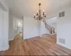 Unfurnished dining area featuring light wood-type flooring and a chandelier