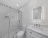 Bathroom with toilet, walk in shower, and vanity