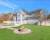 Back of property featuring a deck, a fire pit, and a yard