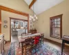 Dining room featuring vaulted ceiling with beams and a notable chandelier