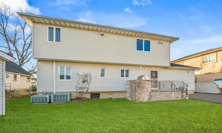 Rear view of property with central AC and a yard