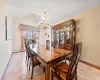 Tiled dining room with lofted ceiling, a baseboard heating unit, and a chandelier