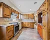 Kitchen with dishwasher, stainless steel gas range oven, sink, range hood, and tasteful backsplash