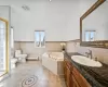 Bathroom featuring a tub to relax in, tile walls, baseboard heating, and a wealth of natural light