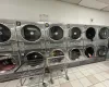 Clothes washing area with stacked washer / dryer, washing machine and dryer, and light tile patterned flooring