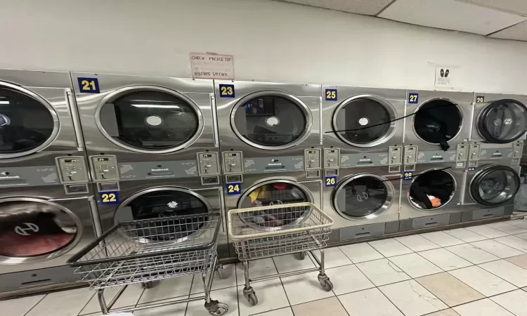 Clothes washing area with stacked washer / dryer, washing machine and dryer, and light tile patterned flooring