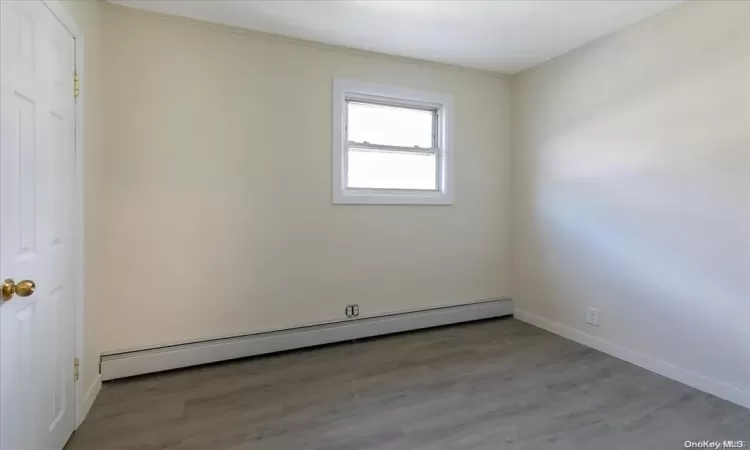 Bedroom 2 featuring hardwood / wood-style floors and a baseboard heating unit