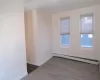 Unfurnished room with a baseboard heating unit and hardwood / wood-style flooring