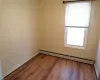 Spare room with baseboard heating and hardwood / wood-style floors