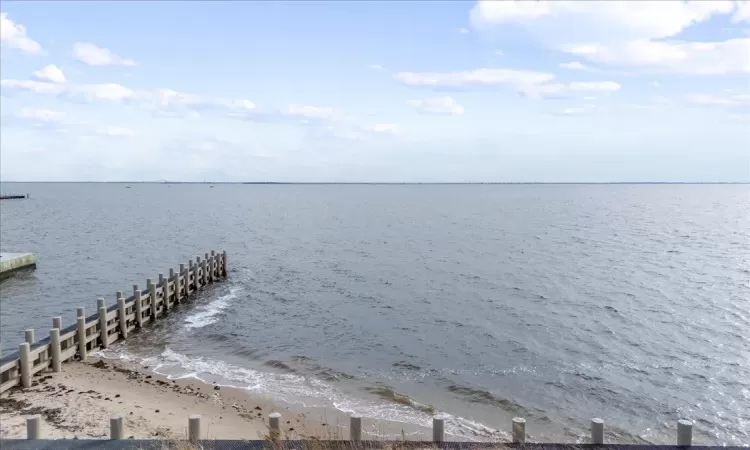 Dock area with a water view and a view of the beach