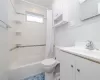 Full bathroom featuring toilet, shower / bath combination with curtain, and vanity