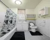 Full bathroom featuring vanity, toilet, shower / bathtub combination with curtain, and tile walls