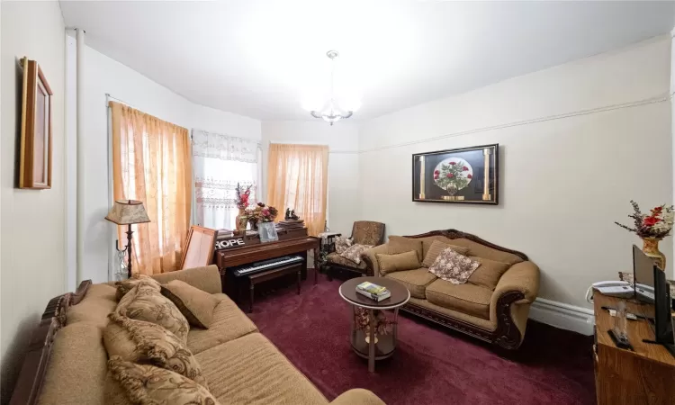 Living room featuring a chandelier and dark colored carpet