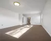 Unfurnished room with dark carpet and ceiling fan