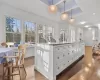 Kitchen with dark hardwood / wood-style floors, stainless steel appliances, custom range hood, decorative backsplash, and white cabinetry