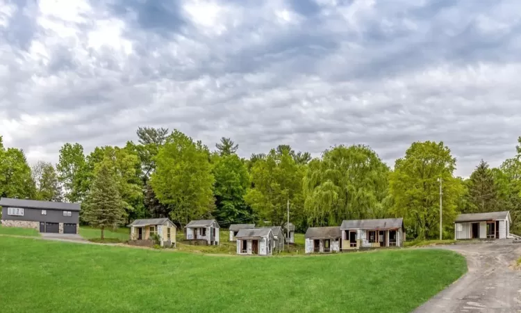 View of community featuring a lawn and a storage unit