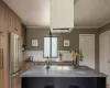 Kitchen featuring sink, high end refrigerator, ornamental molding, and kitchen peninsula