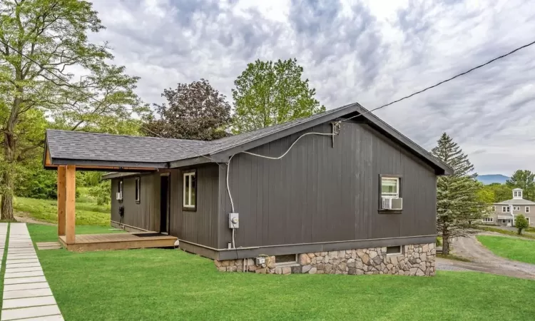 View of home's exterior with cooling unit and a lawn