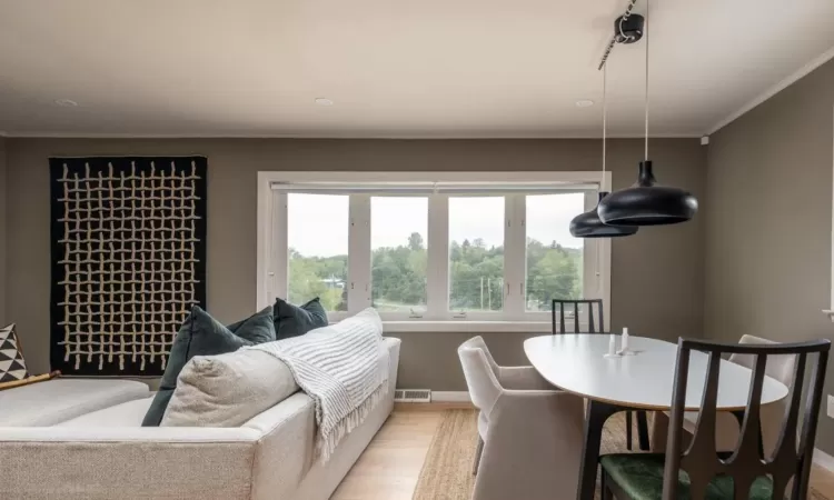 Living room featuring crown molding and light hardwood / wood-style flooring