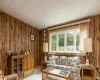 Carpeted living room featuring wooden walls