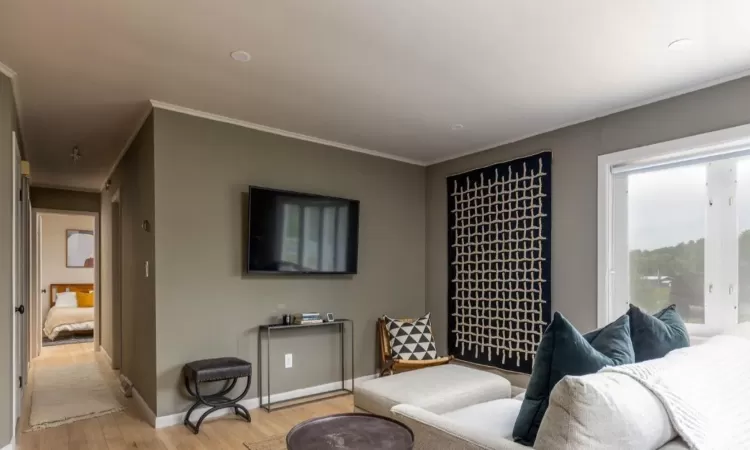 Sitting room featuring light wood-type flooring and ornamental molding