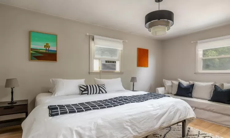 Bedroom with wood-type flooring and cooling unit